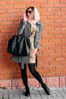 girl posing on a background of red brick wall photo