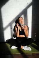 Portrait of fit woman putting on a protective face mask. photo