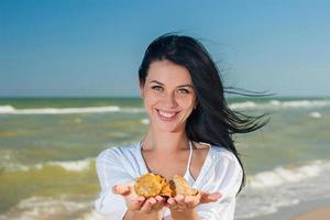 mujer sosteniendo conchas marinas foto