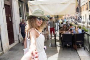 hermosa chica es un chico de la mano en el centro de Venecia foto