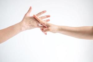 Hands of two people playing rock paper scissors, hands showing shape of scissors symbol and paper symbol, concept of business competition. photo