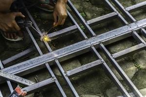 Hands of man welding steel structure photo