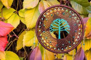 atrapasueños hecho a mano con hilos de plumas y cuerda de cuentas colgando foto