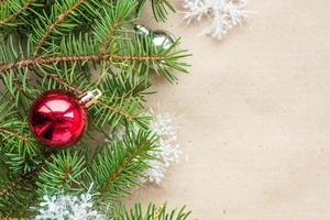 Festive christmas border with red and silver balls on fir branches and snowflakes on rustic beige background photo