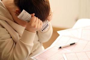 A sad young girl suffers from a loss after looking the unlucky result of the lottery gambling. The concept of losing the lottery and spend money photo