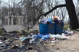 el bote de basura está lleno de basura y desechos. retiro intempestivo de basura en zonas pobladas foto