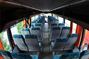 interior del bus turístico para excursiones y viajes largos. muchos asientos libres y lugares para equipaje pequeño foto