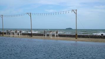 dinning table near swimming pool with sea background video