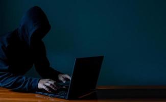 Hackers work on laptops in the dark. The concept of information security in the Internet network and information espionage. photo