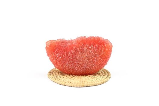 Piece of ripe red siam ruby pomelo , pummelo, grapefruit with no peel on weaven isolated on white background. photo