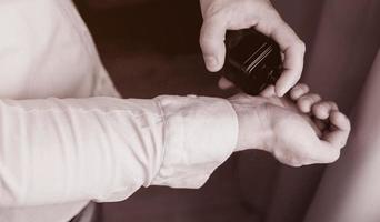 man in shirt using cologne photo