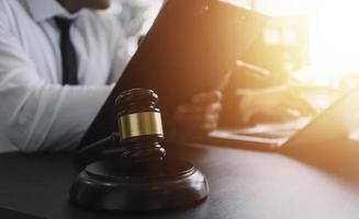 Male lawyer working with contract papers and wooden gavel on tabel in courtroom. justice and law ,attorney, court judge, concept. photo