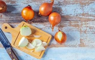 White onion slices on a wooden chopping board   for cooking and fresh white onion on wooden background photo