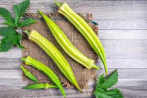 Healthy vegetables of fresh green okra and leaf okara on gray background.Top view photo