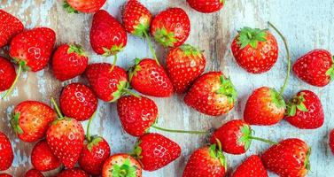 primer plano de fresas rojas frescas sobre un fondo azul de madera vieja foto