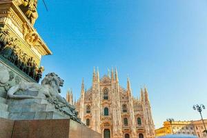 Lion marble statue near famous church Milan Cathedral Duomo di Milano. Panoramic view of top tourist attraction on piazza in Milan Lombardia Italy. Wide angle view of old Gothic architecture and art. photo