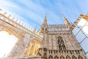 Roof of Milan Cathedral Duomo di Milano with Gothic spires and white marble statues. Top tourist attraction on piazza in Milan, Lombardia, Italy. Wide angle view of old Gothic architecture and art. photo