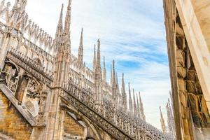 techo de la catedral de milán duomo di milano con agujas góticas y estatuas de mármol blanco. principal atracción turística en la plaza de milán, lombardía, italia. vista panorámica de la antigua arquitectura gótica y el arte. foto