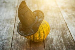 Jack O Lantern Halloween pumpkin with black witch hat on wooden background. Halloween party concept. Holiday season greeting, trick of treat spooky. photo