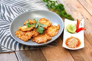 Corn Fritters With chili sauce placed on a wooden table photo