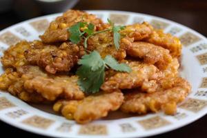 Corn Fritters With chili sauce placed on a wooden table photo