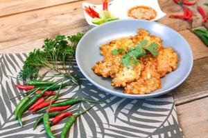 Corn Fritters With chili sauce placed on a wooden table photo