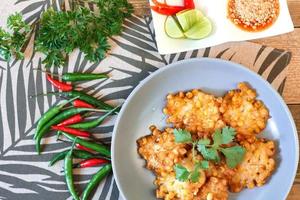 Corn Fritters With chili sauce placed on a wooden table photo