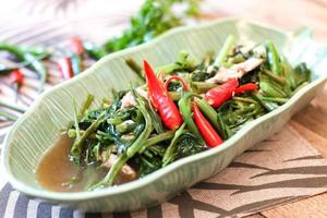 Stir-fried morning glory in a black dish Stir Fried Morning Glory is also one of the most delicious dishes you can eat in Thailand. photo