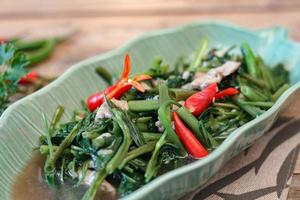 gloria de la mañana salteada en un plato negro gloria de la mañana frita también es uno de los platos más deliciosos que puedes comer en tailandia. foto