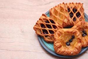 Lattice Jam Tart served in a plate on a wooden table. photo