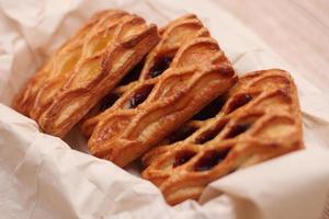 Lattice Jam Tart served in a plate on a wooden table. photo