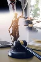 Justice and law concept.Male judge in a courtroom with the gavel, working with, computer and docking keyboard, eyeglasses, on table in morning light photo