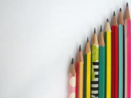 flat lay of pencils are arranged vertically on a white background. photo