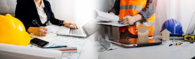 Two colleagues discussing data working and tablet, laptop with on on architectural project at construction site at desk in office photo