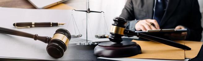 Business and lawyers discussing contract papers with brass scale on desk in office. Law, legal services, advice, justice and law concept picture with film grain effect photo