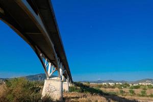 Arch of a modern bridge crossing a river photo