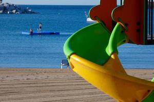 tobogán colorido en la arena de la playa, juegos infantiles foto