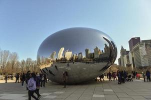 Chicago, Il, USA - march 22, 2018 -   reflecting the buildings on the Cloud Gate statue in Millenium Park, central city, with some tourist walking around photo