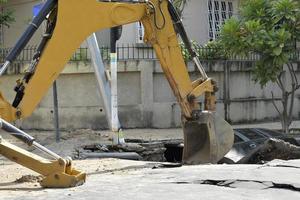 Rio de Janeiro, Brazil - march 02, 2018 -   backhoe works in the removal of a car that has fallen into a hole, caused by leakage of water pipe photo