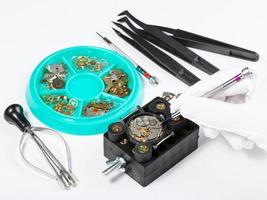 repairing old mechanical watch on white table photo