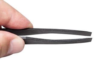 male fingers hold black plastic flat tweezers photo