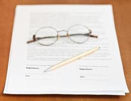 contract, golden pen and eyeglasses on table photo