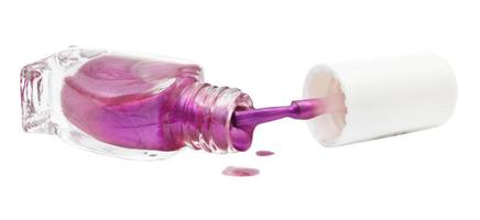 bottle and spilled purple nail polish isolated photo