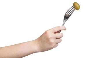 hand holding dinning fork with impaled green olive photo