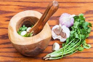 wooden mortar with cilantro grass and garlic photo