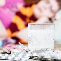 dissolving drug in water and pills on table photo