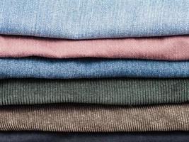 stack of various jeans and corduroy slacks photo