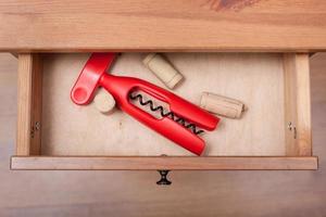 red corkscrew and cork from wine bottles in drawer photo