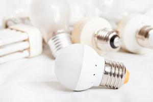 energy saving LED lamp and several old light bulbs photo