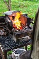 Blacksmith heats steel rod in forging furnace photo